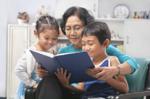 Asian_woman_reading_to_2_children.jpg